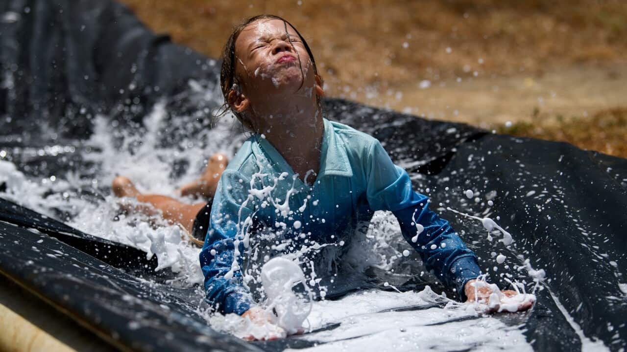 Local children are seen on a homemade waterslide.