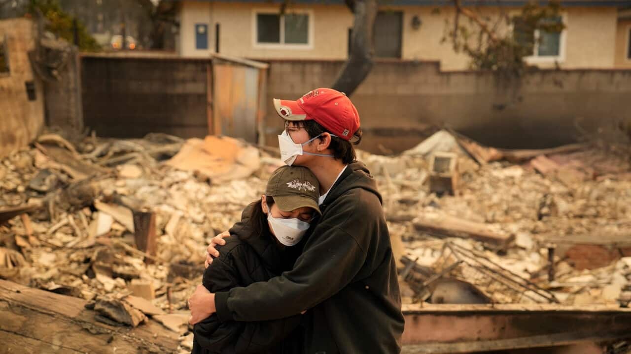 Two Californians hold each other in front of their destroyed home in Altadena (AAP).jpg