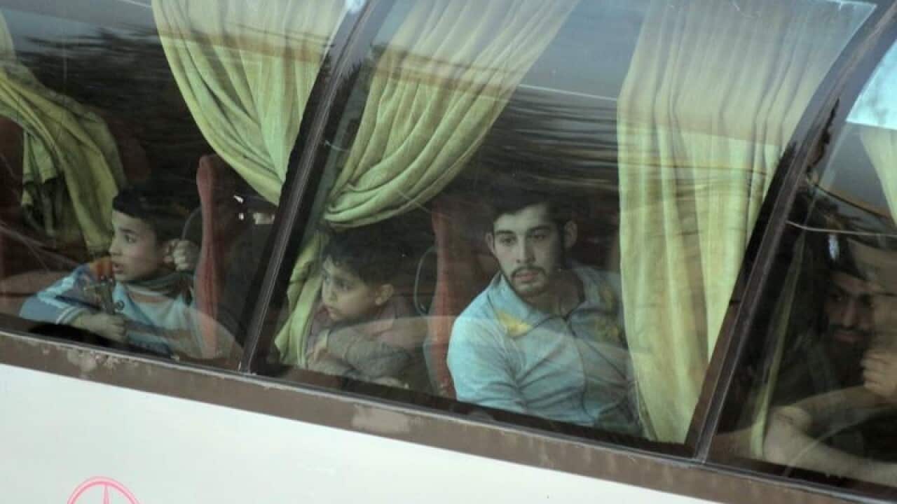 Syrian rebels and their families on a government bus