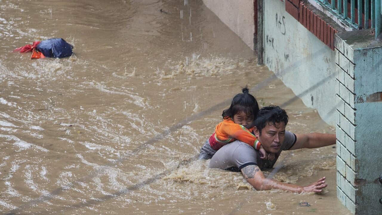 A man and his daughter struggle to leave a flooded area following torrential rains in Kathmandu, Nepal.