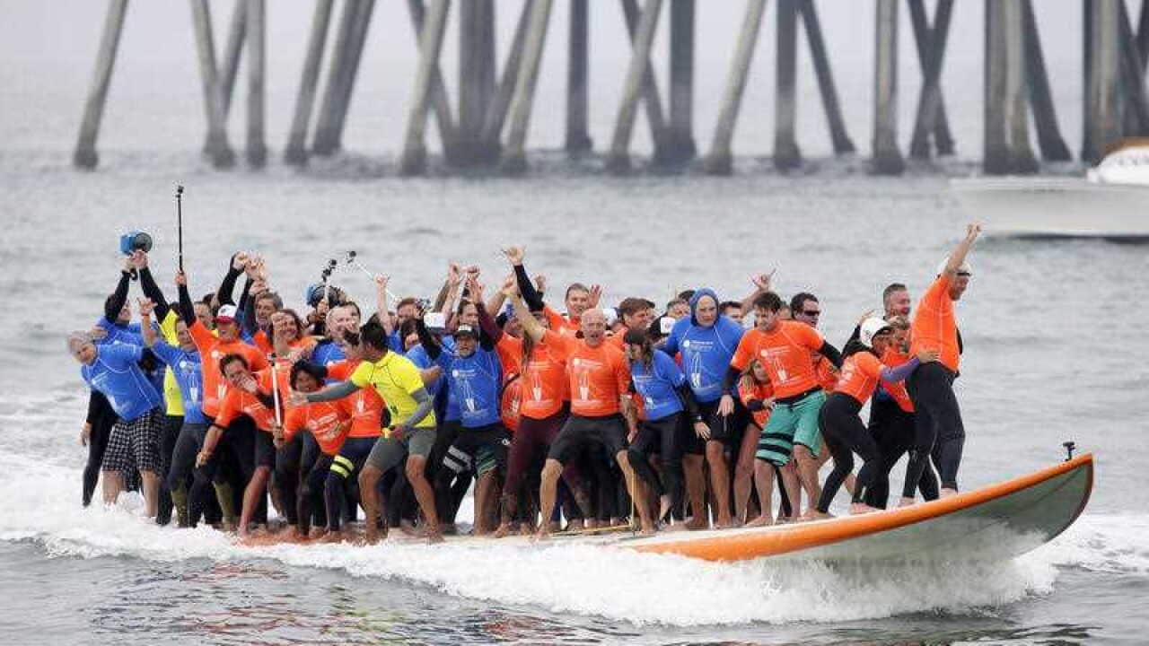 - Sixty-six surfers from around the world ride a custom built 42-foot, 1300 pound surfboard for 12 seconds to break the GUINNESS WORLD RECORDS® for “Most People Riding a Surfboard at Once” on Saturday, June 20, 2015 in Huntington Beach, CA.