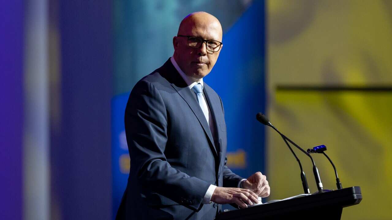 A man in a suit at a lecturn.