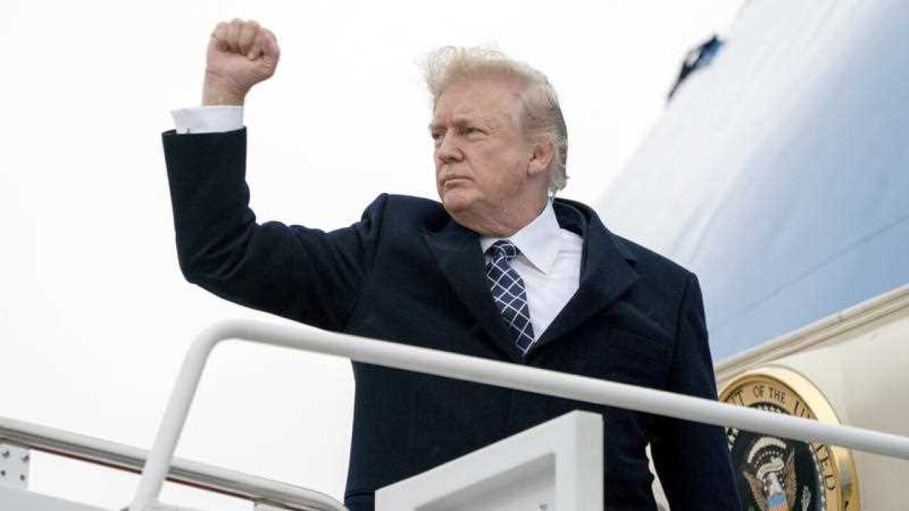 President Donald Trump gestures as he boards Air Force One at Andrews Air Force Base.