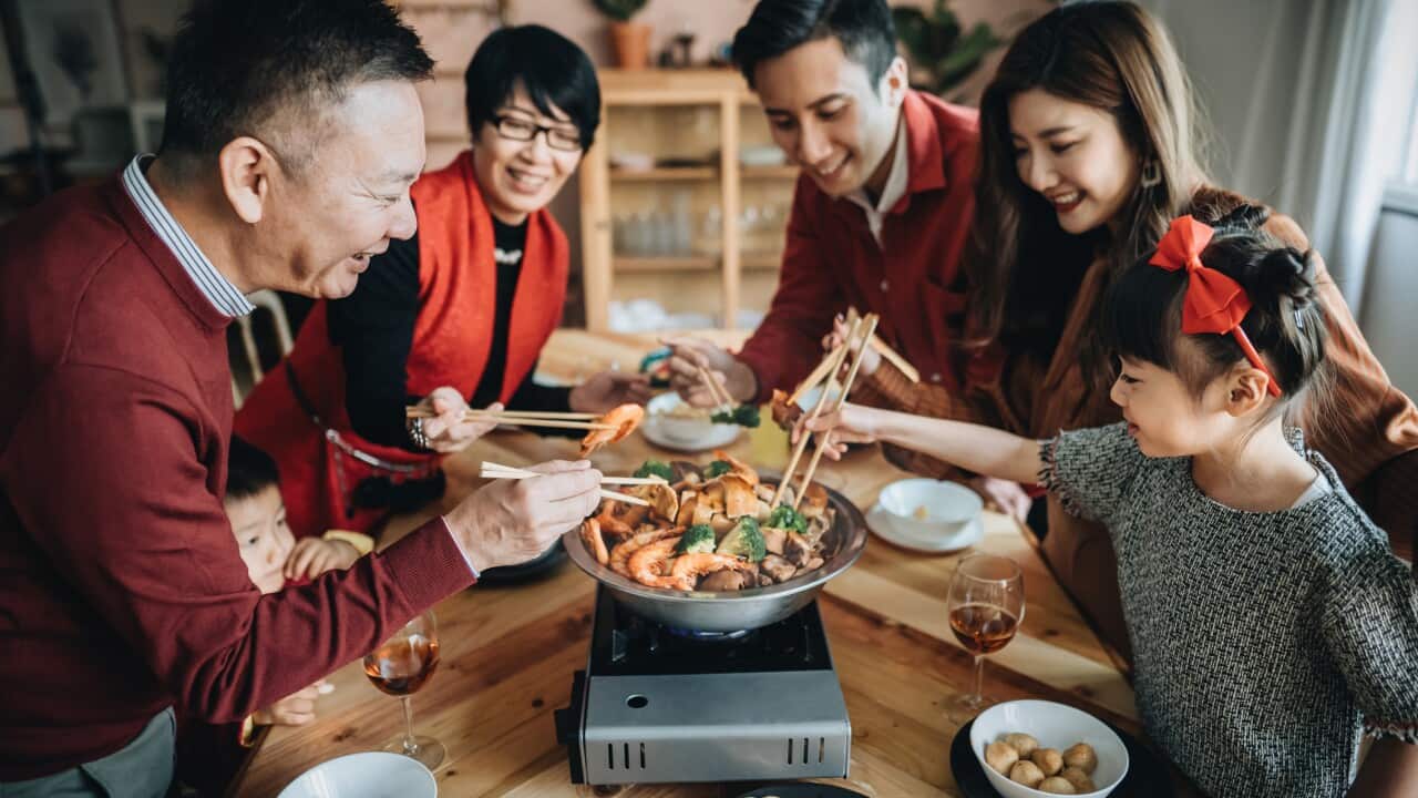 Tre generazioni di una famiglia asiatica che celebrano il Capodanno Cinese e si godono il tradizionale poon choi durante la cena.