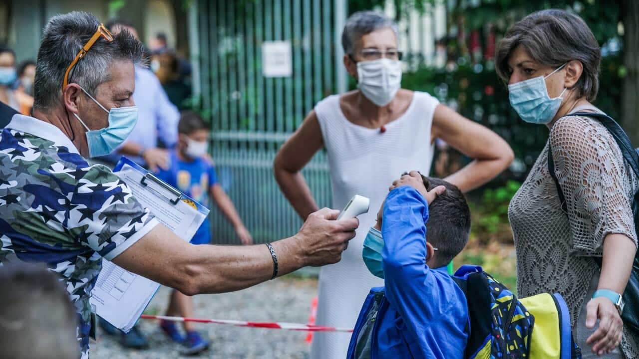 Students have their temperature checked as they arrive at Baricco primary school in Turin, Italy.
