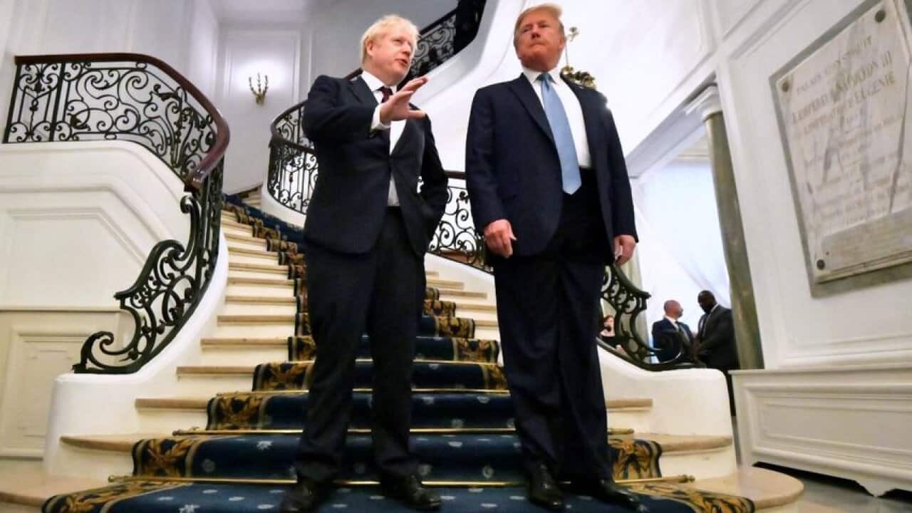US President Donald J. Trump (R) and Britain's Prime Minister Boris Johnson (L) pose as they arrive for a bilateral meeting during the G7 summit in Biarritz