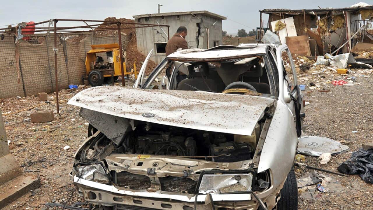 Destroyed buildings and a vehicle following a suicide bombing