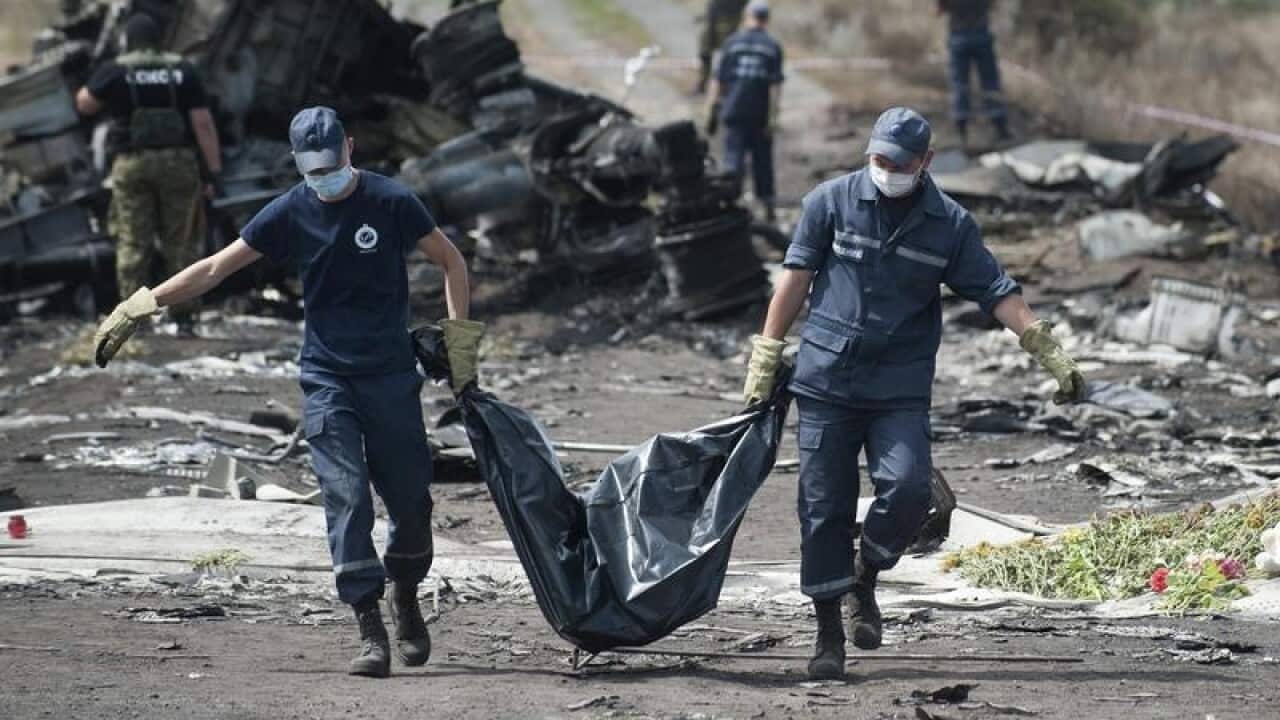 A file image of emergency workers carrying a body from MH17.