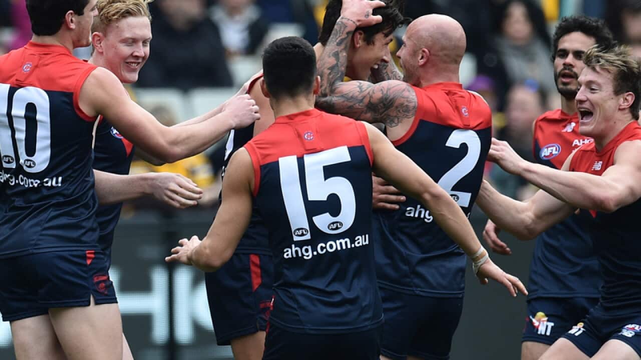 Melbourne players celebrate after kicking a goal
