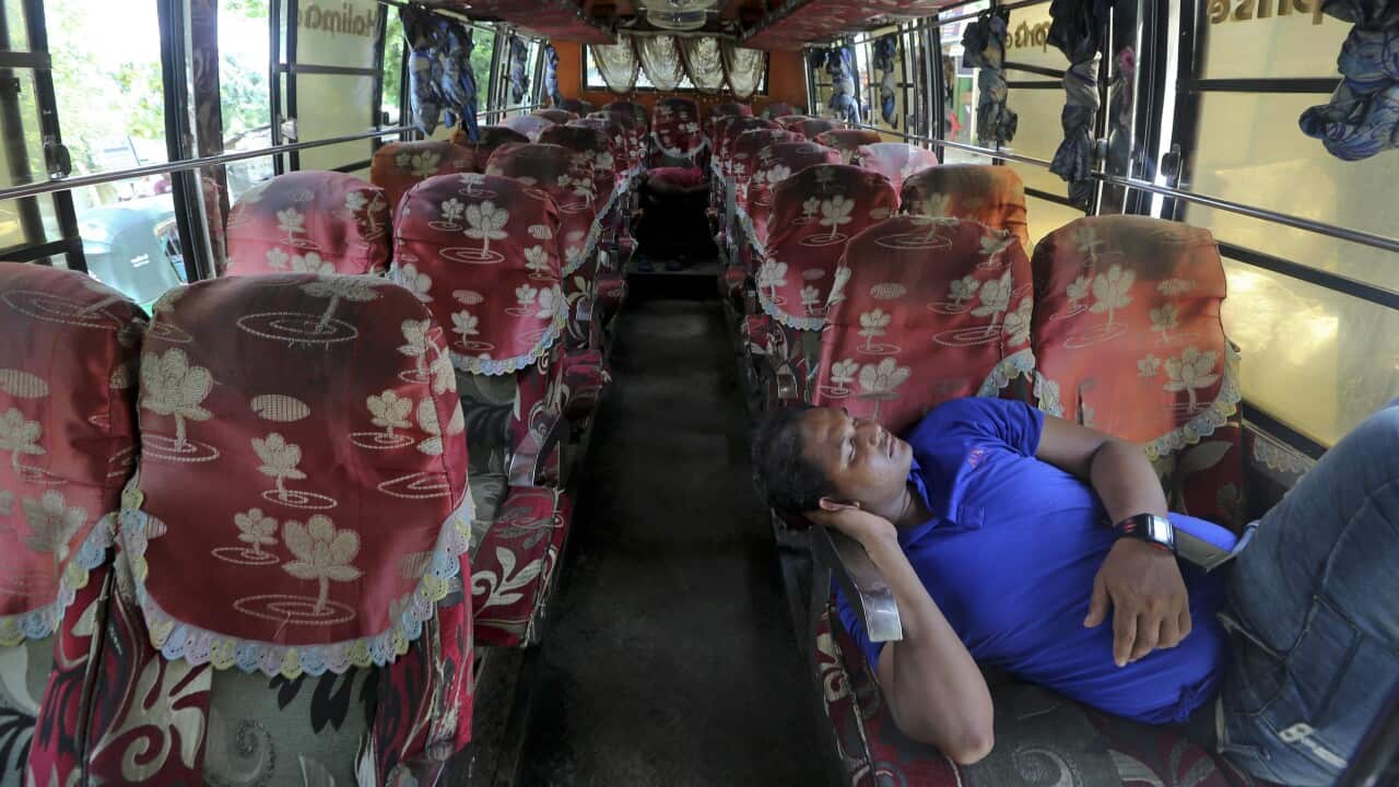 The driver of a bus that was brought to take Rohingya refugees to the Myanmar border takes a rest.