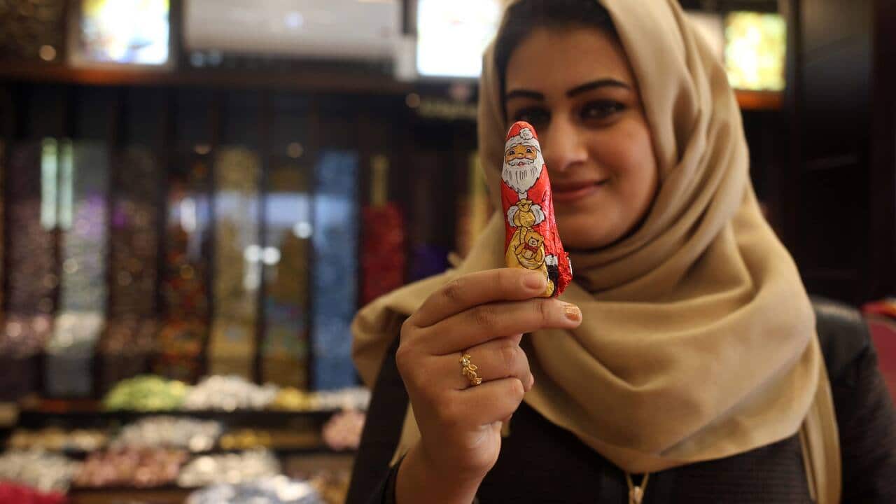 A Palestinian woman poses with a Santa candy