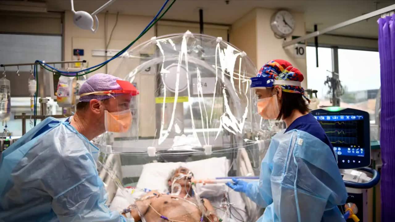 A supplied image shows ICU nurse Michelle Spiteri and anaesthetist and intensive care physician Dr Forbes McGain attending to a COVID-19 patient in Melbourne.