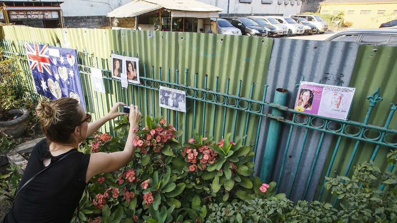 A tourist takes a picture at the former site of the Sari Club.