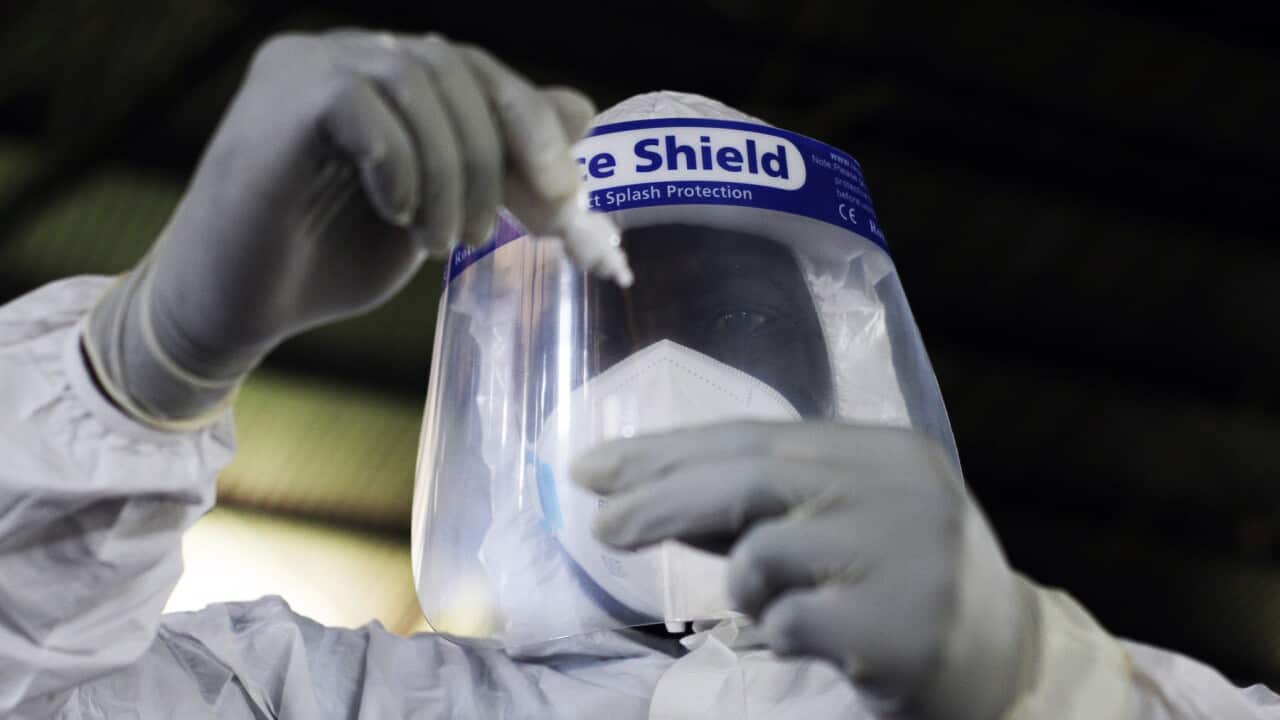 An official prepares a sample at COVID-19 testing site