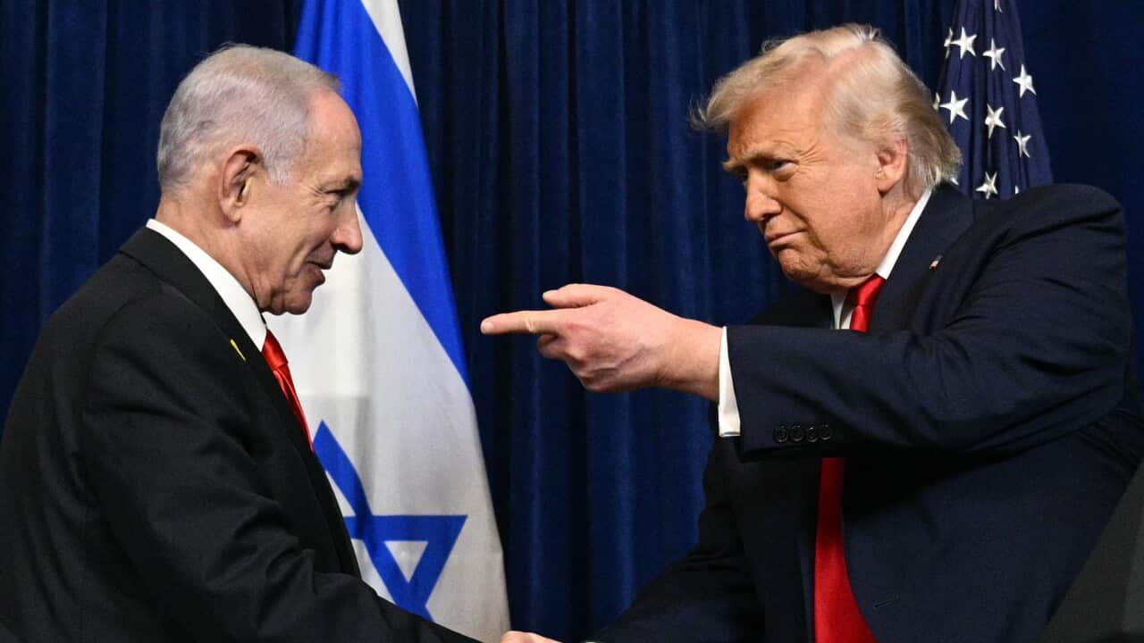 Donald Trump points his finger at Benjamin Netanyahu as they shake hands.