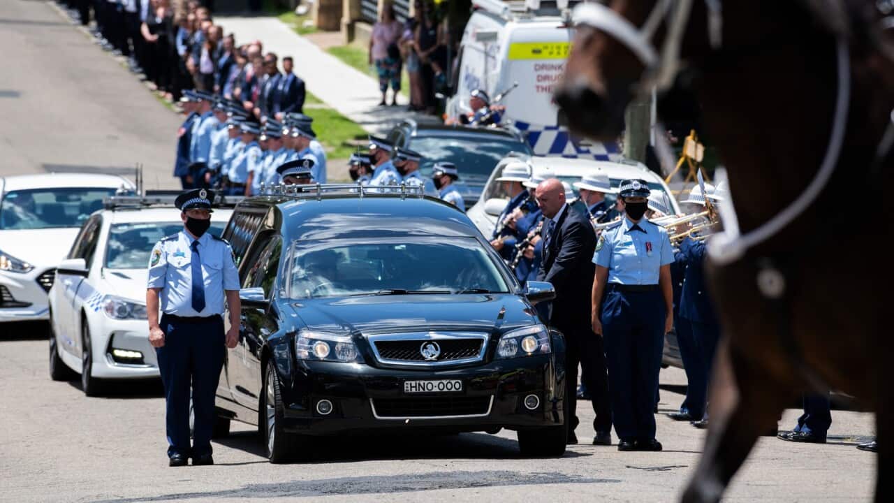 Members of NSW Police are seen lining the street as the hearse proceeds through the town at the conclusion of the police funeral of Senior Constable Kelly Foster