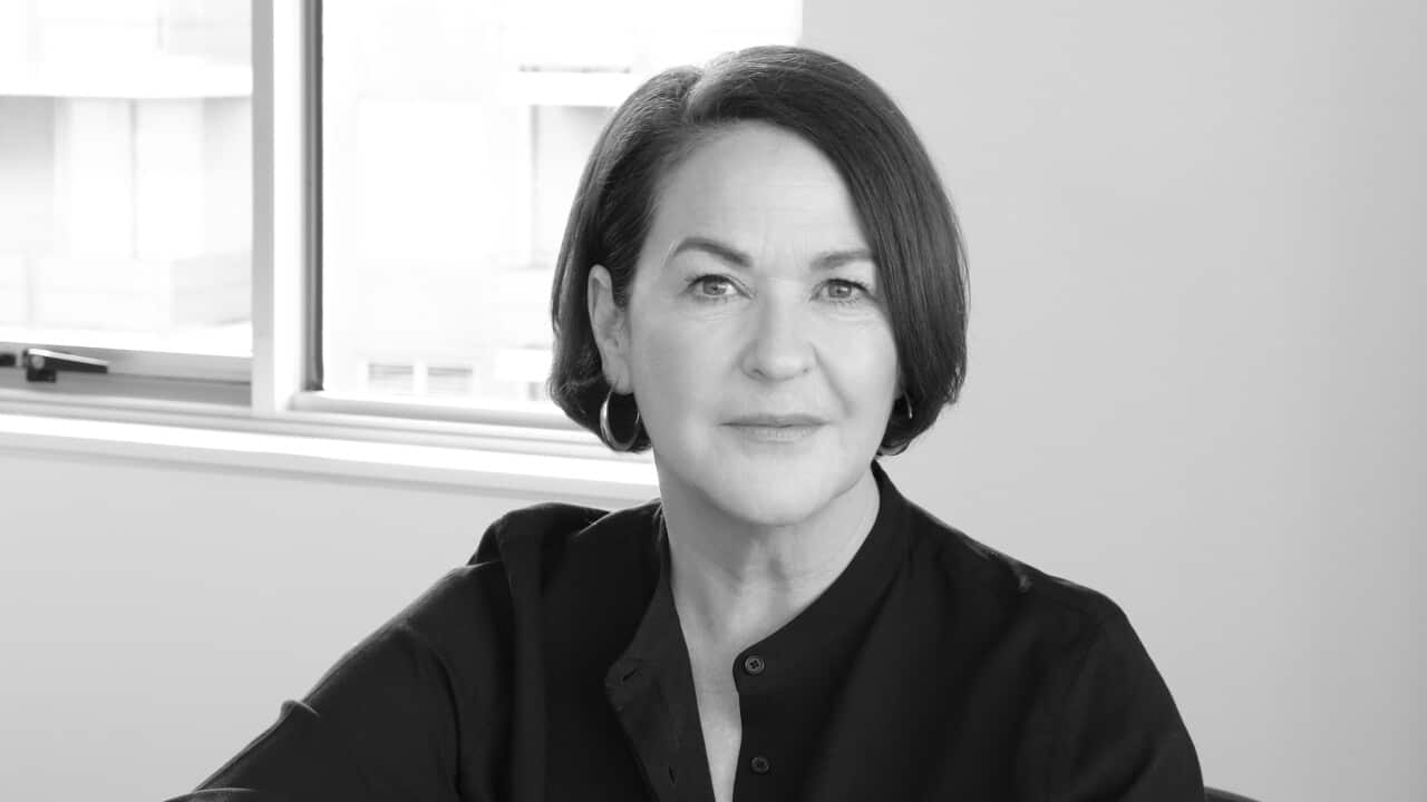 a black and white photo of a woman sitting down