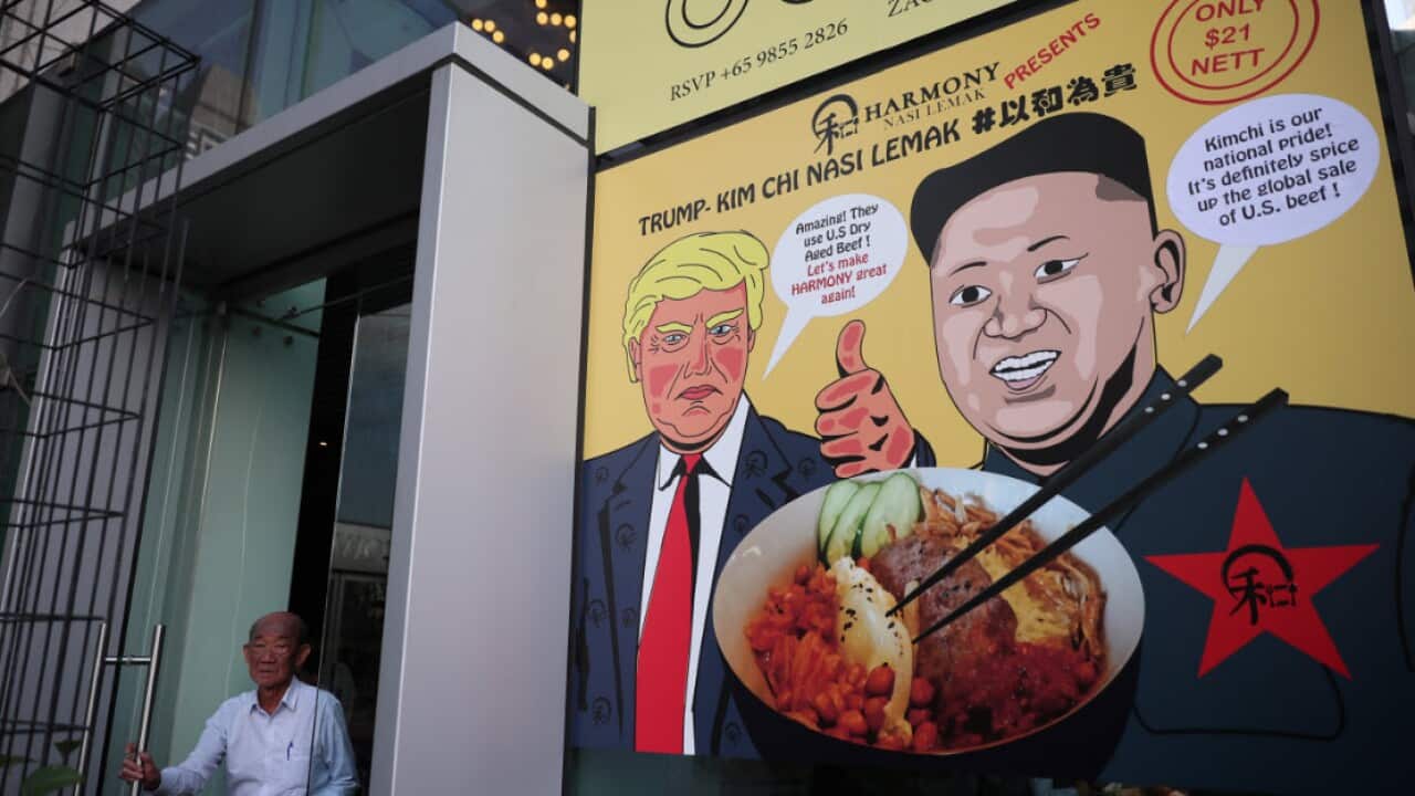 A man exits a door next to a poster depicting a promotional dish of 'Trump-Kim Chi Nasi Lemak' at a restaurant in Singapore.