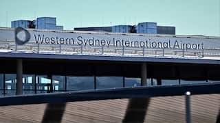 An industrial setting with a sign reading Western Sydney International Airport.