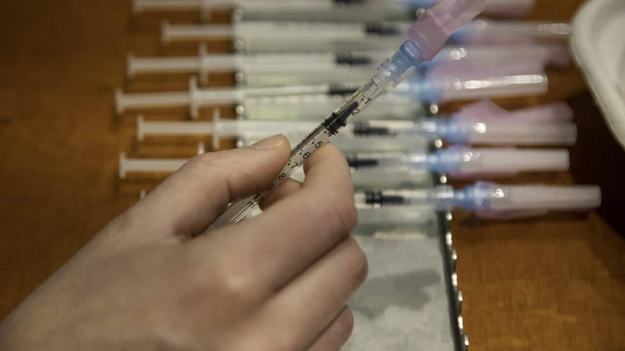 A health worker prepares to administer a Covid-19 booster