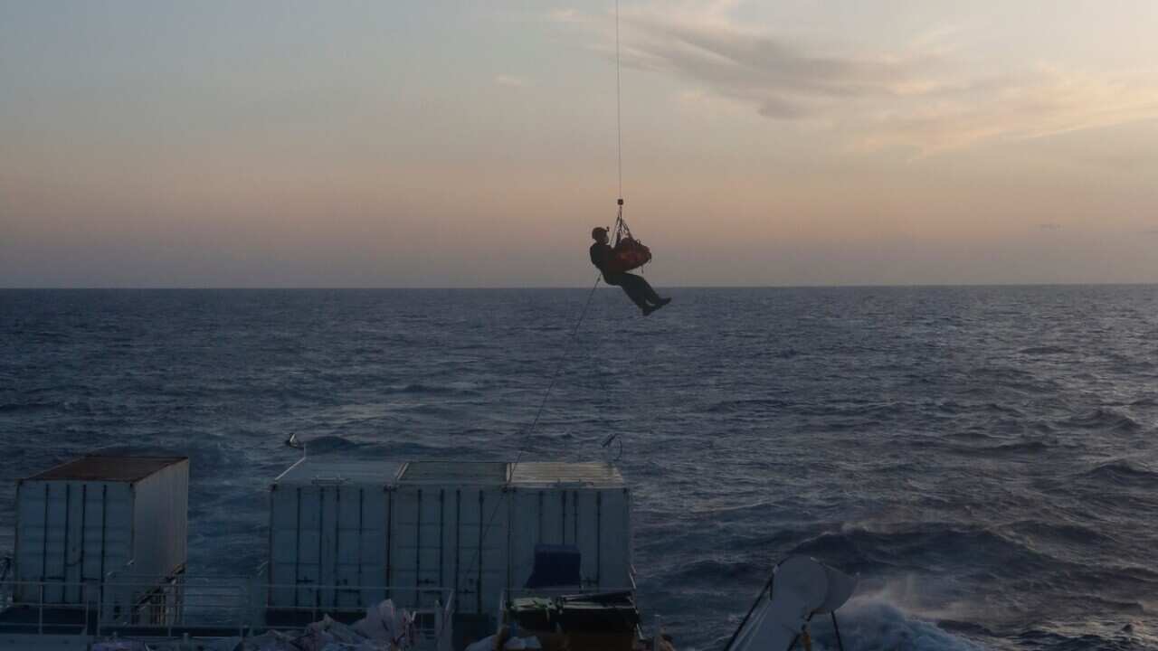 A pregnant Nigerian woman is evacuated by a Maltese Armed Forces helicopter from aboard the Ocean Viking