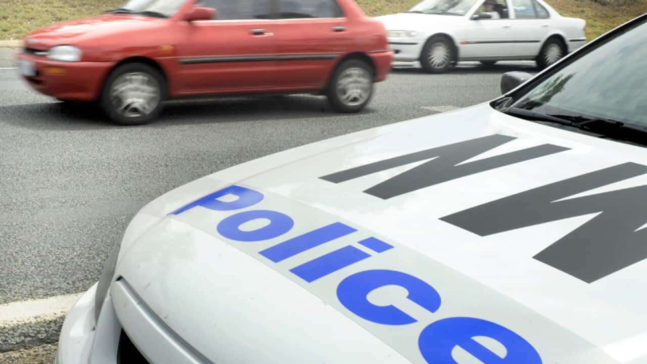 A police car monitors traffic.