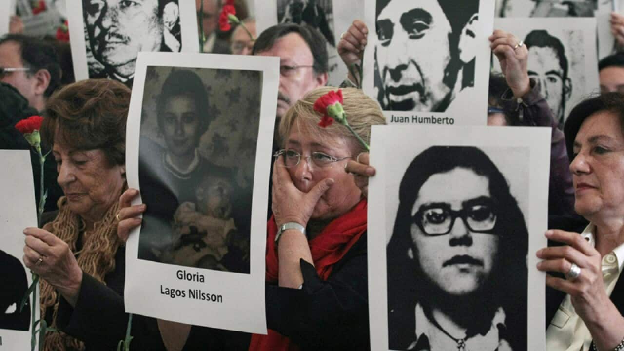 People hold photographs of missing people of the Pinochet dictatorship