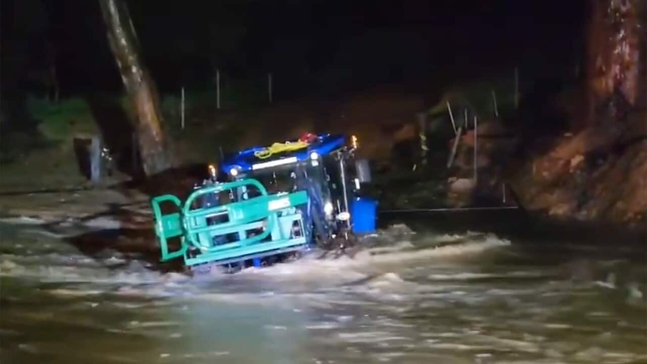 Blurry image of vehicle being swept away in floodwaters