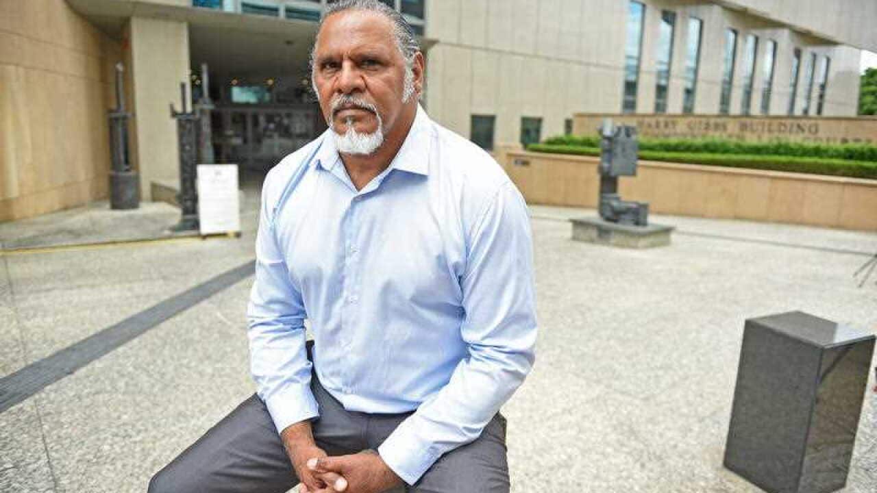Adrian Burragubba, spokesperson for the Wangan and Jagalingou (W&J) Traditional Owners' Council, poses for photos outside the Federal Court in Brisbane, Monday, Nov. 23, 2015.