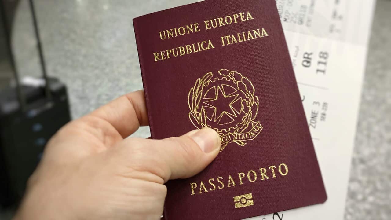 Inside the airport, man with Italian passport in hand and international airfare.