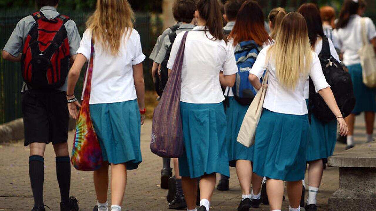 A group of high school students walk together during a school excursion.