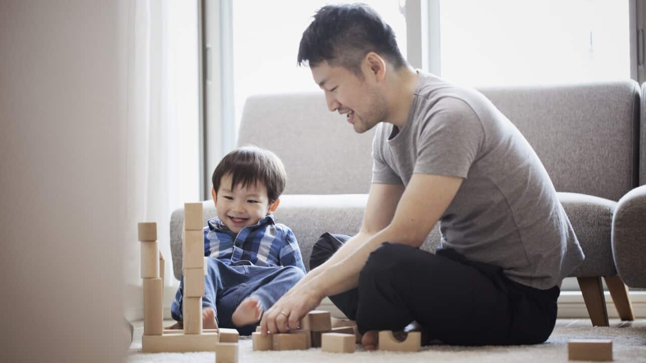 Father and son playing with building blocks together