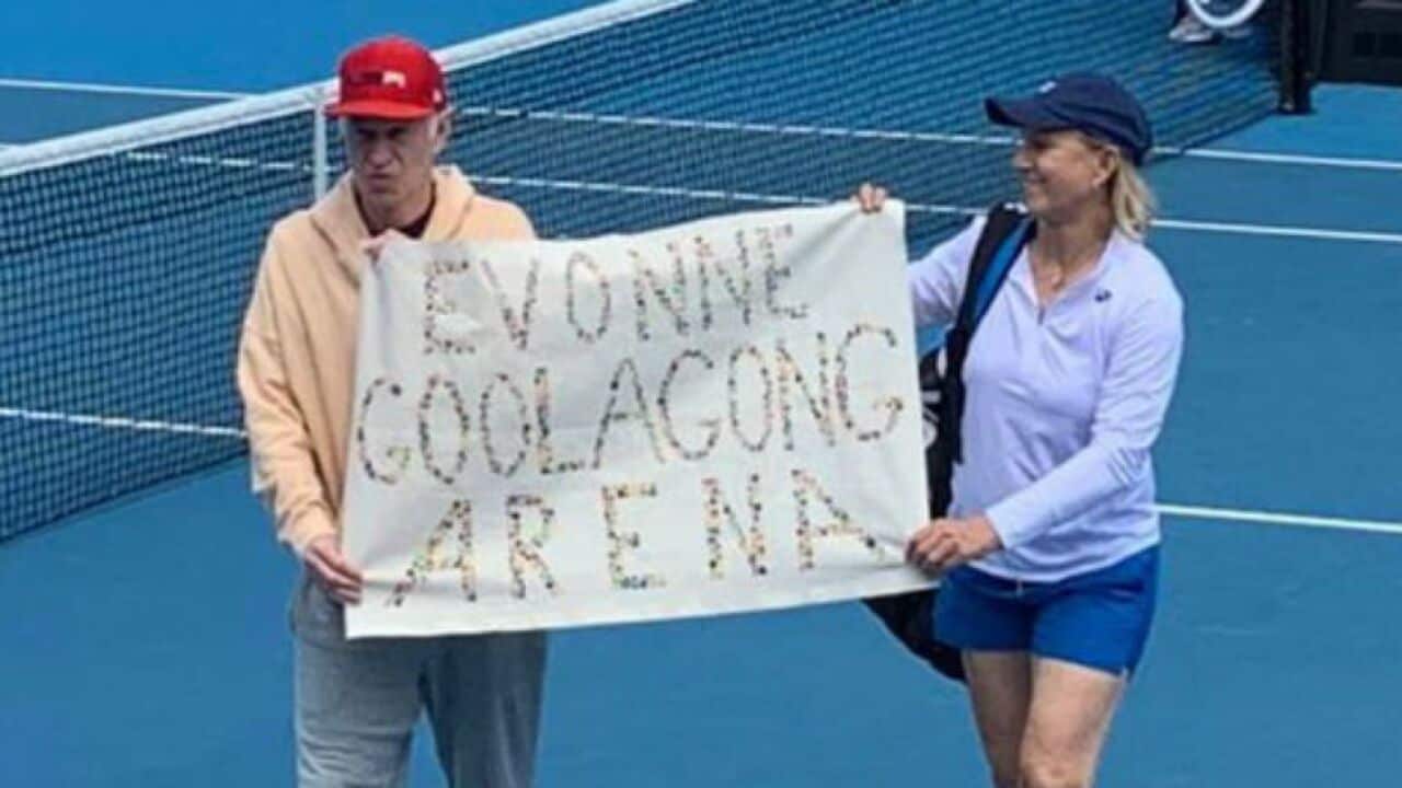 Martina Navratilova and John McEnroe hold up a banner at Margaret Court arena.