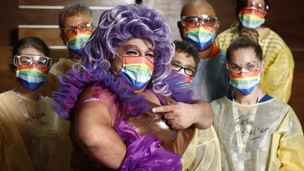 Frock Hudson (centre) poses for a photograph with health staff at the Victorian Pride Centre in Melbourne, Monday, October 18, 2021