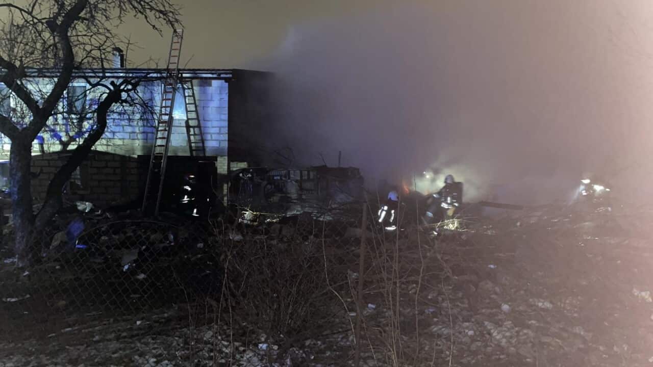 Firefighters work at the crash site of a cargo plane near the Vilnius International Airport