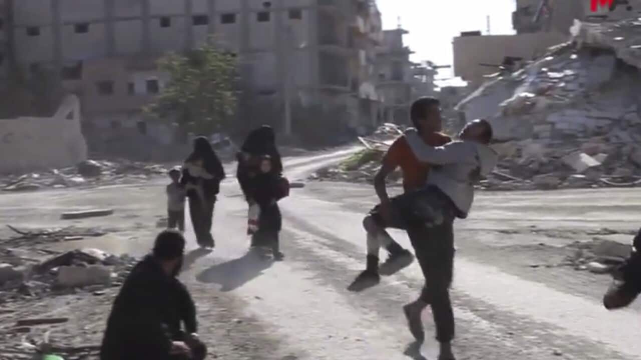 Syrian civilians run on a damaged street as they fleeing from the areas that still controlled by the Islamic State militants, in Raqqa, Syria.