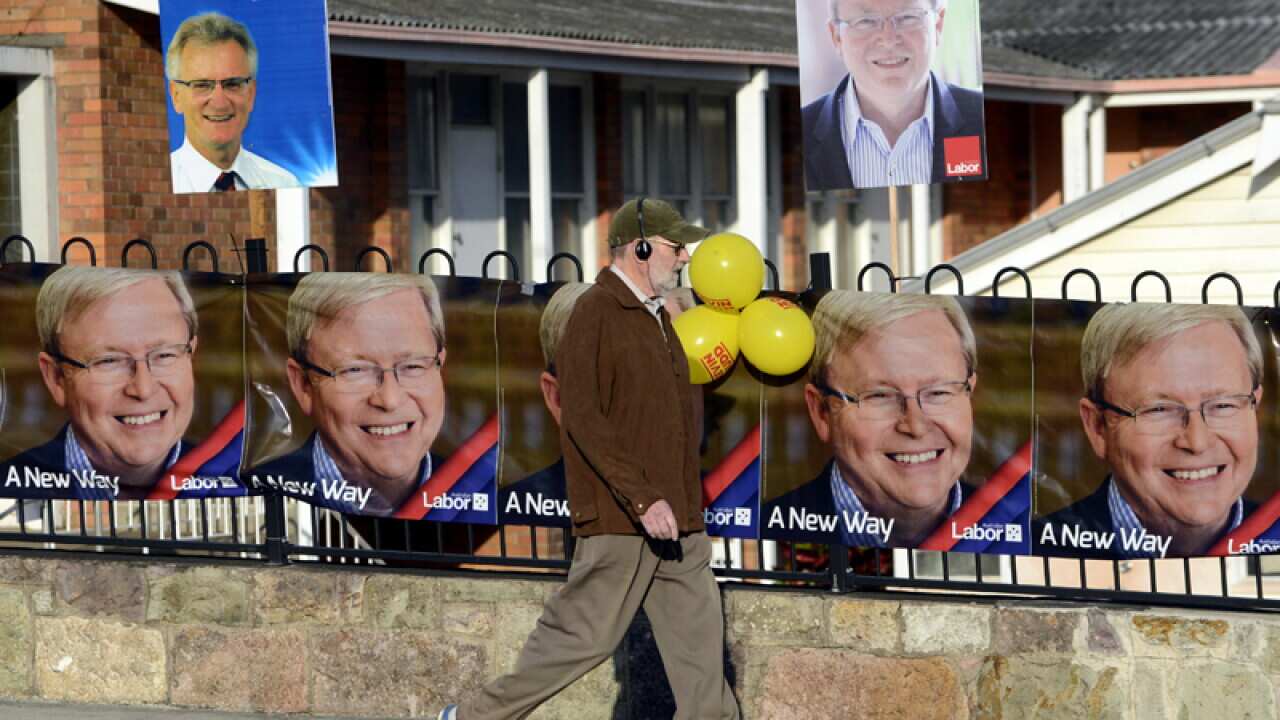 A man walks past election signs in the seat of Griffith