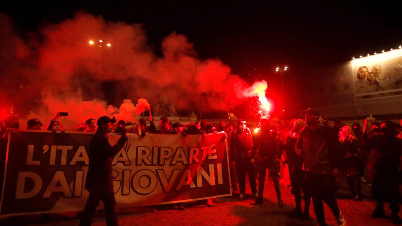 People light flares as they protest against the government restriction measures to curb the spread of COVID-19, in Rome Tuesday, Oct. 27, 2020.