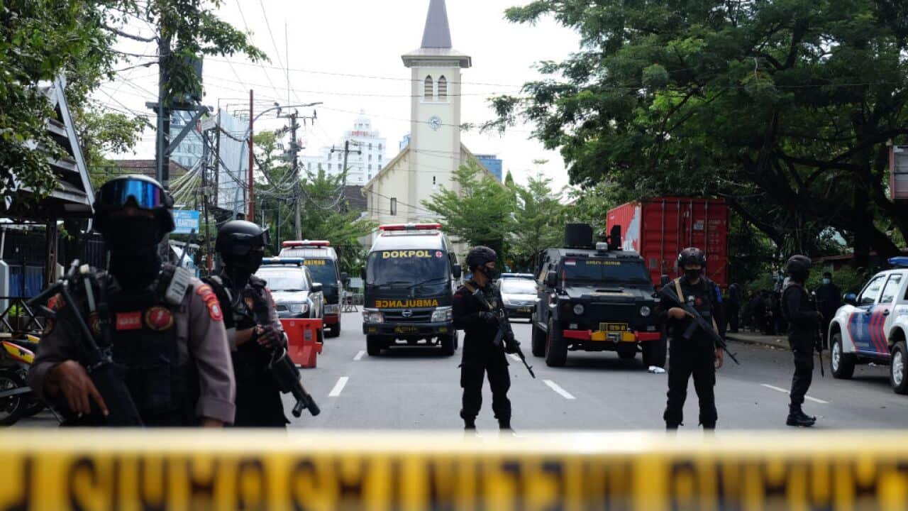 Police officers stand guard in the front of the Sacred Heart of Jesus Cathedral after a suicide bomb attack in Makassar, Indonesia on 28 March 2021.