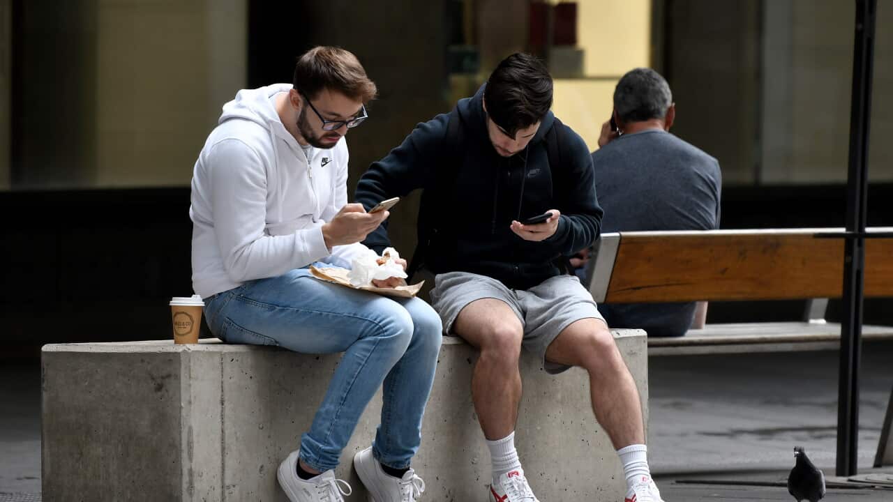 People are seen sitting close together on a bench