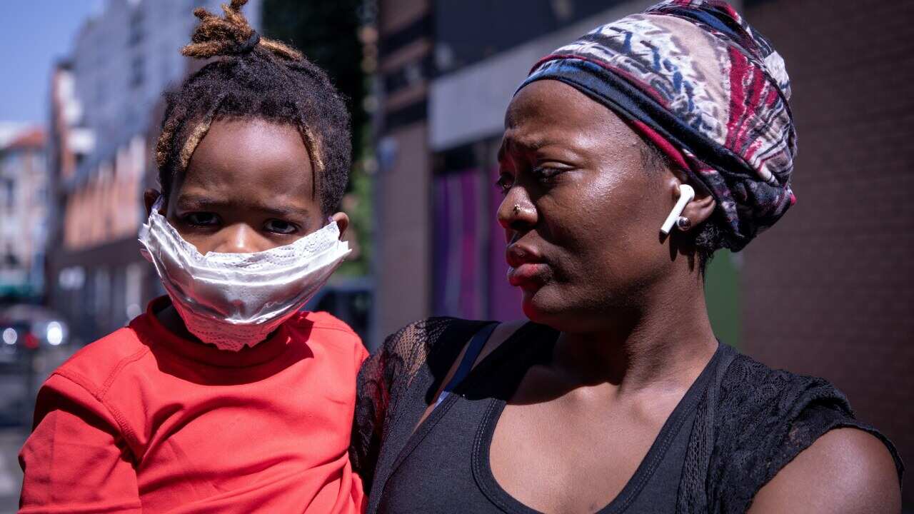 A child with her mother wearing face masks as a precaution in the Paris suburb of Saint Denis, France.