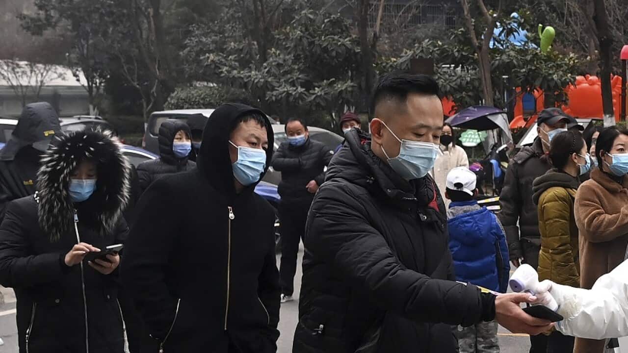 In this photo released by China's Xinhua News Agency, people line up for COVID-19 tests in Xi'an in northwestern China's Shaanxi Province.