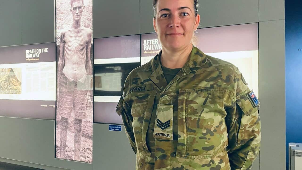 Sgt Pearce in front of a photo of her great uncle (SBS).jpg