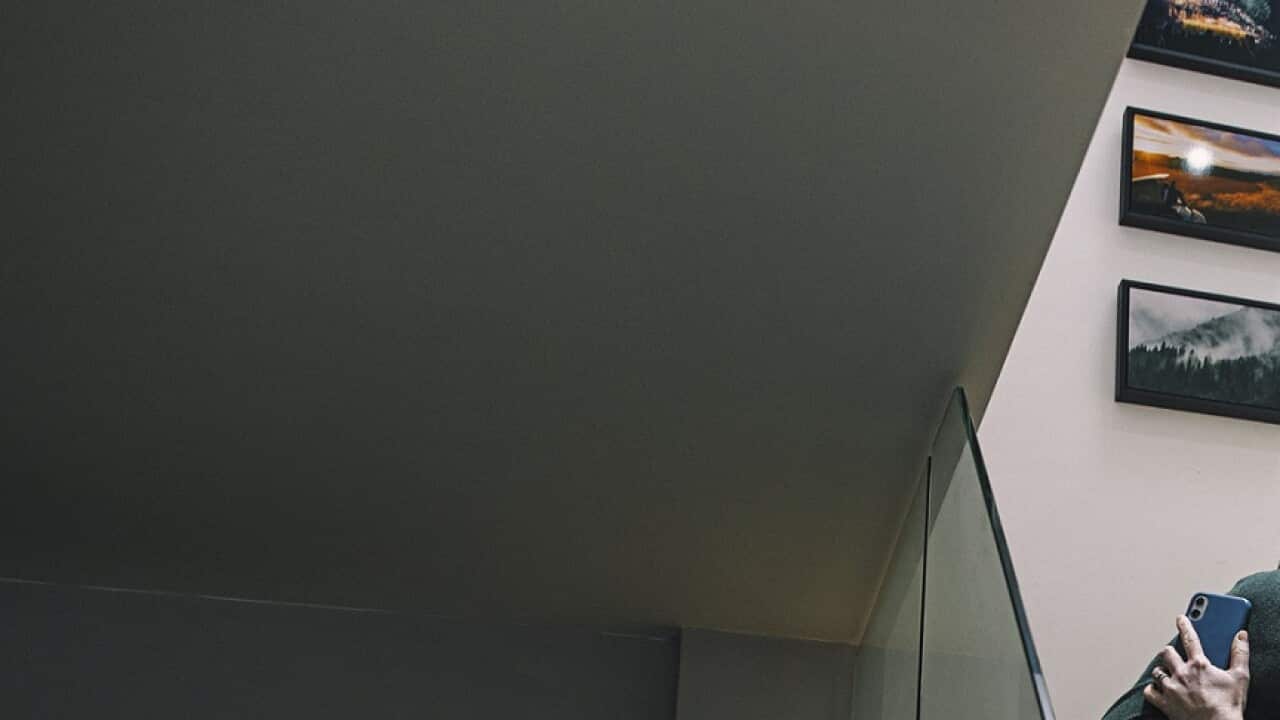 Couple having a cuddle on the stairs after a 'bad news' phone call