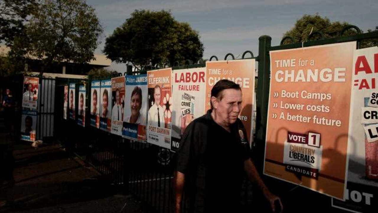 The public walk past in the final minutes of voting at St Mary's Primary School in Darwin