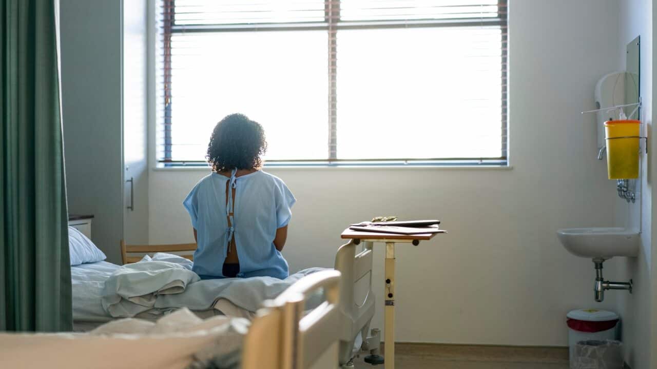 Lonely female patient sitting on hospital bed