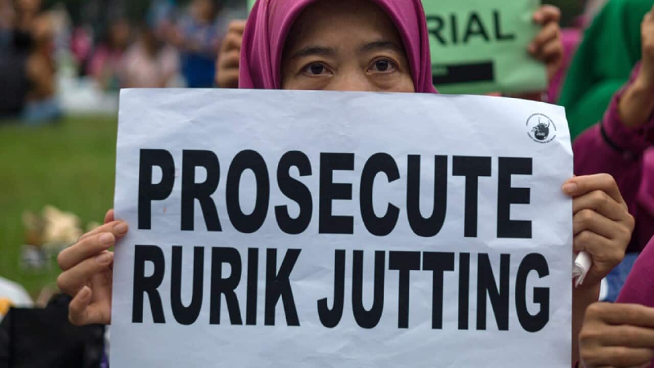 An Indonesian migrant worker holds a sign during a vigil in Hong Kong