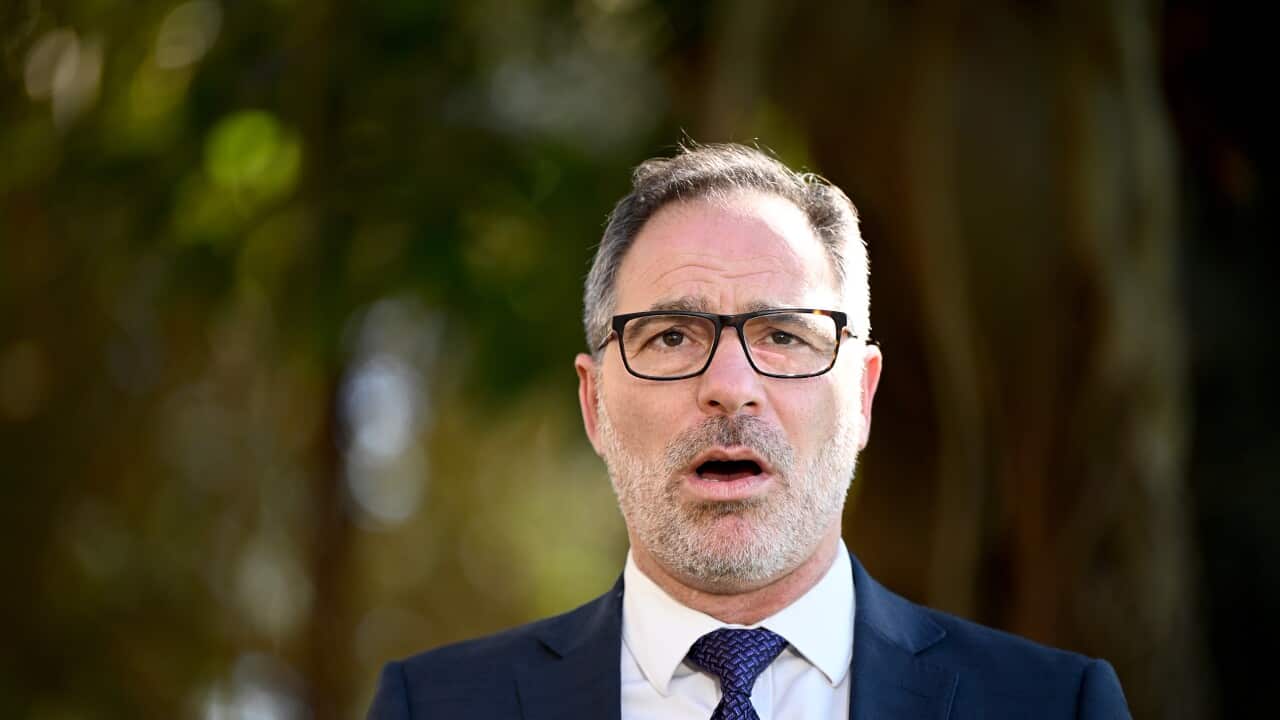 A man in a blue suit and tie speaks.