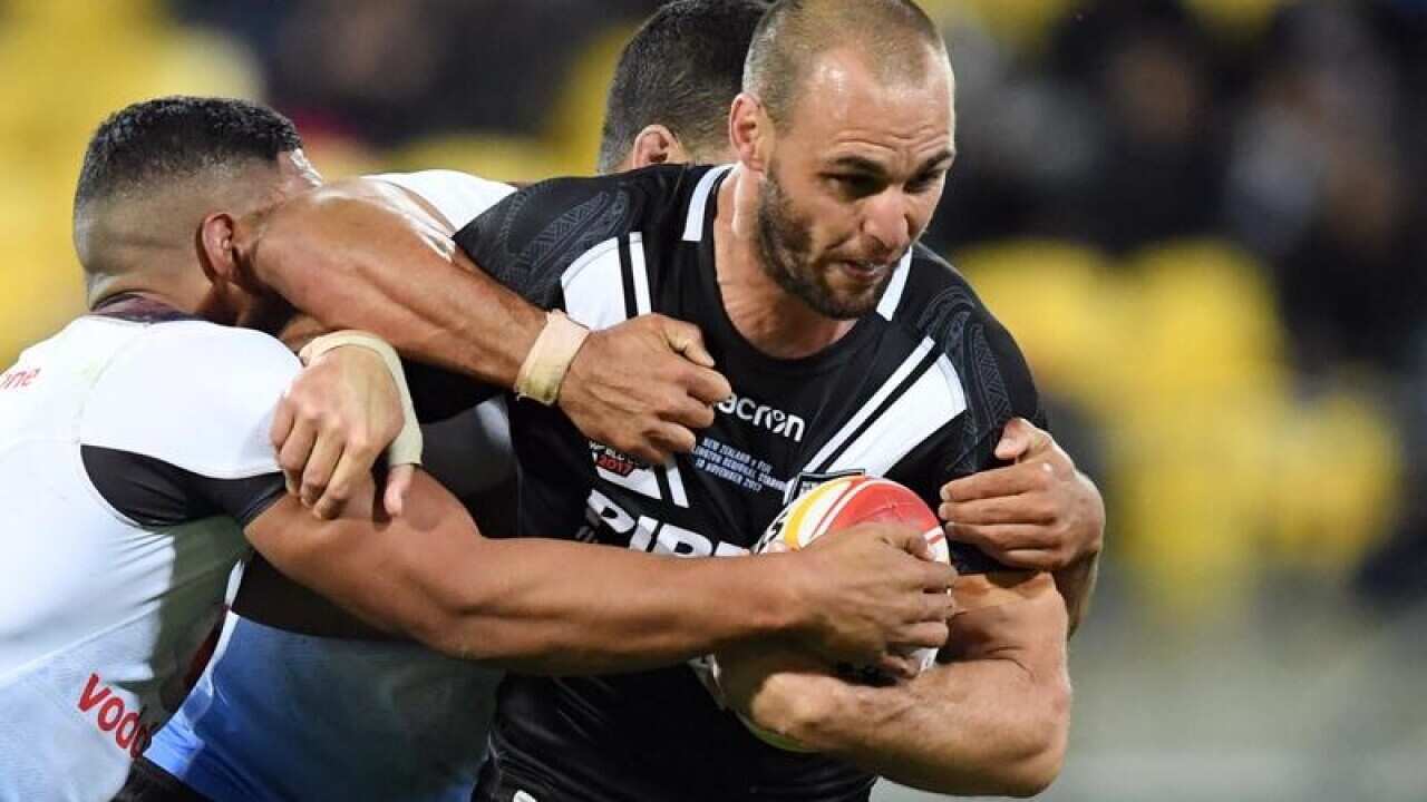 Simon Mannering of New Zealand drags the Fiji defence with him