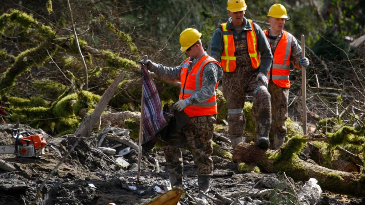 Members of the Washington National Guard search through debris